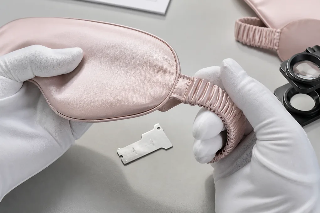 Silk sleep mask seam and covered strap junction examined during a product sample review